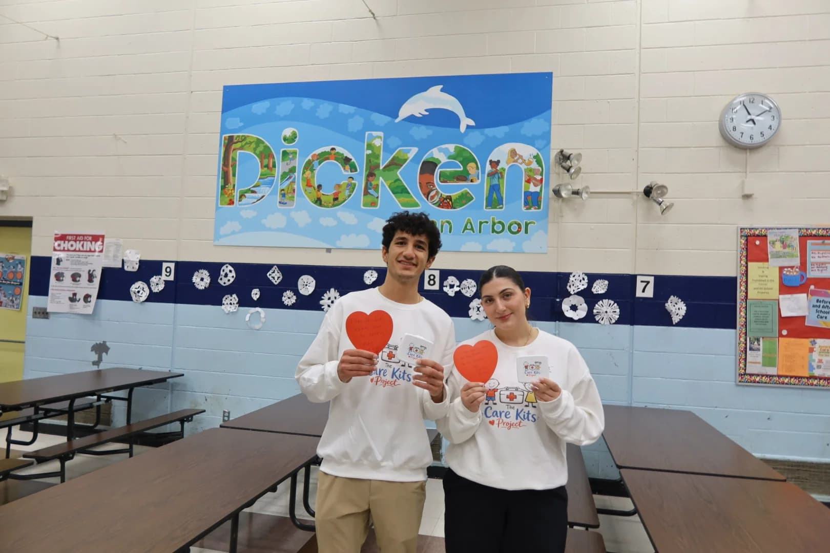 Alexander and Lilyana posing with heart notes and branded stickers at Dicken Elementary