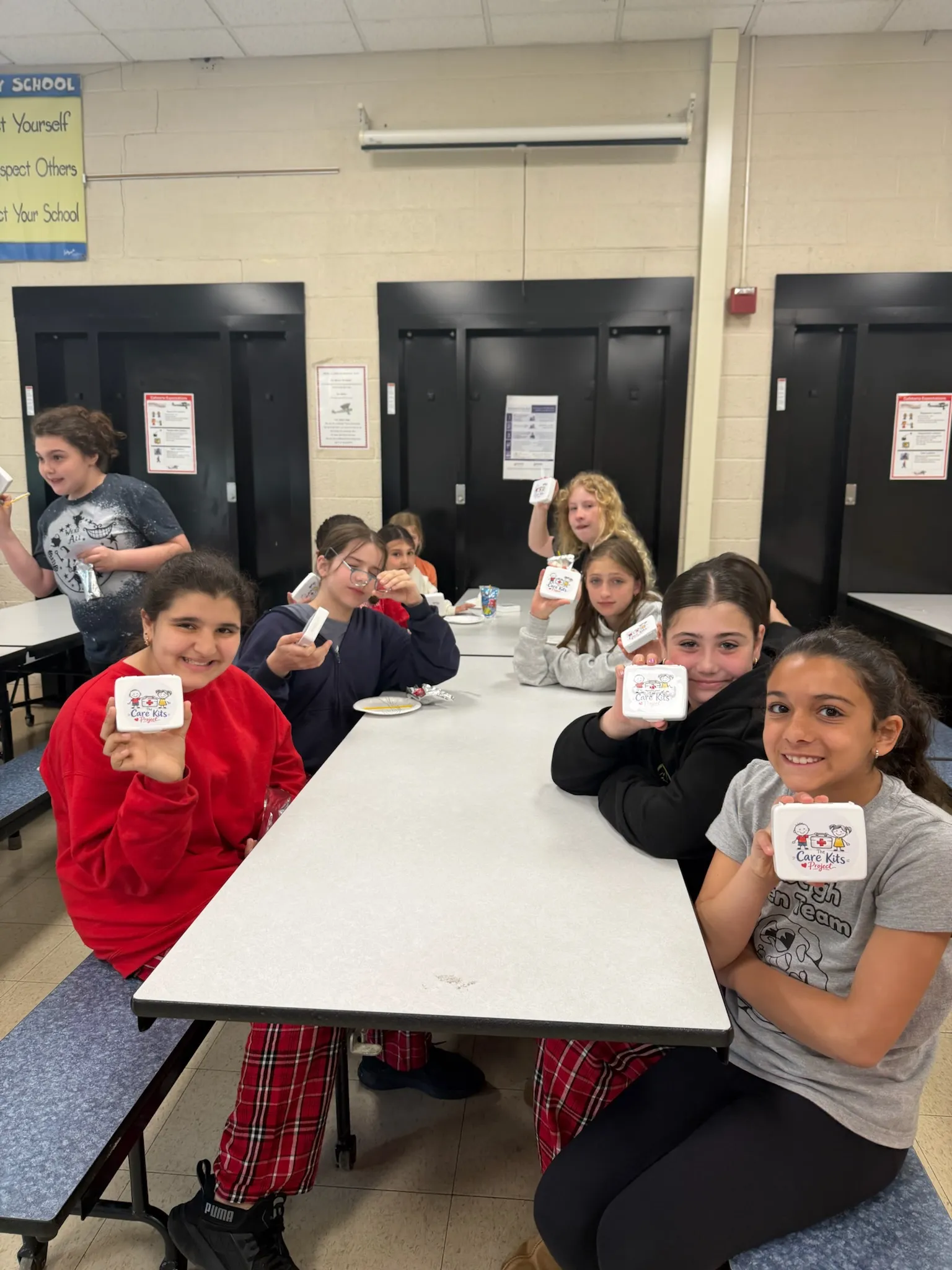A table of students holding up their finished care kits