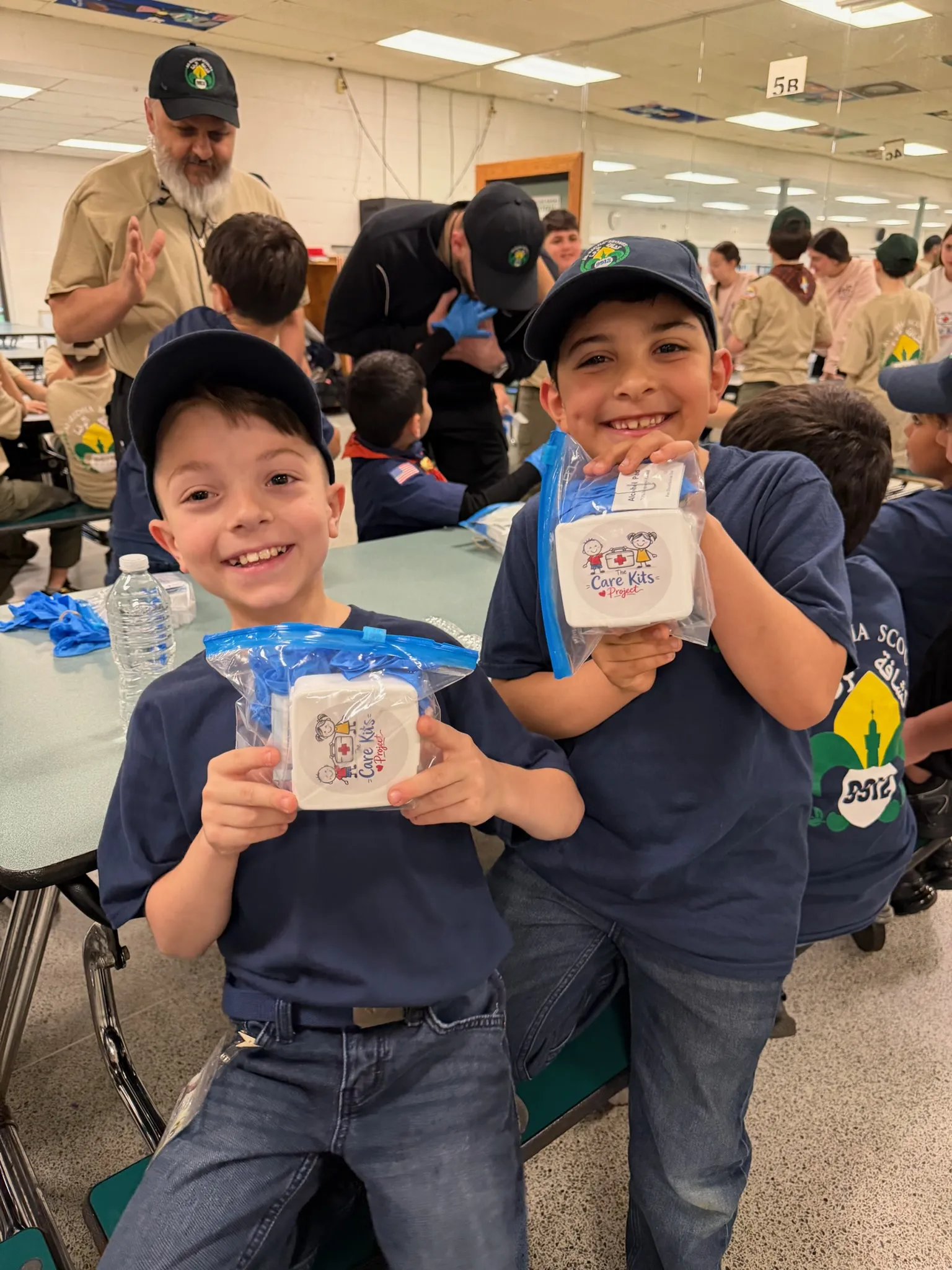 Two boys proudly holding up their finished care kits